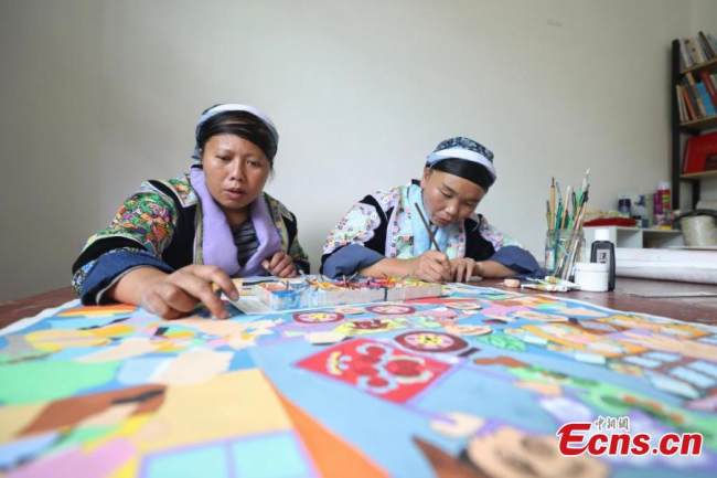 Δύο ζωγράφοι (畫家Huàjiā ) της εθνότητας των Μιάο ζωγραφίζουν σύμφωνα με το στυλ των Μιάο στο χωριό Πινγκπό της κομητείας Λονγκλί της Αυτόνομης Νομαρχίας Τσιεννάν Μπουγί και Μιάο, στην επαρχία Γκουιτζόου της νοτιοδυτικής Κίνας, στις 15 Σεπτεμβρίου 2021.