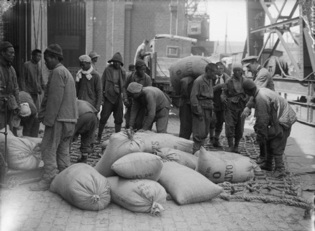 Members of the Chinese Labour Corps loading sacks of oats onto a lorry at Boulogne [Photo: IWM, London]