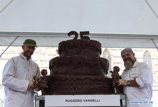 Des artistes posent pour des photos avec leur sculpture en chocolat lors du 25e Festival international du chocolat "Eurochocolate" à Pérouse, en Italie, le 21 octobre 2018. (Photo : Cheng Tingting)