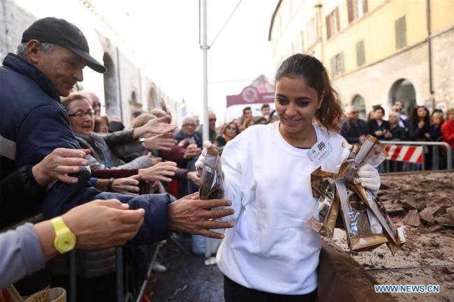 Une employée distribue des morceaux de chocolat au public lors du 25e Festival international du chocolat "Eurochocolate" à Pérouse, en Italie, le 21 octobre 2018. (Photo : Cheng Tingting)