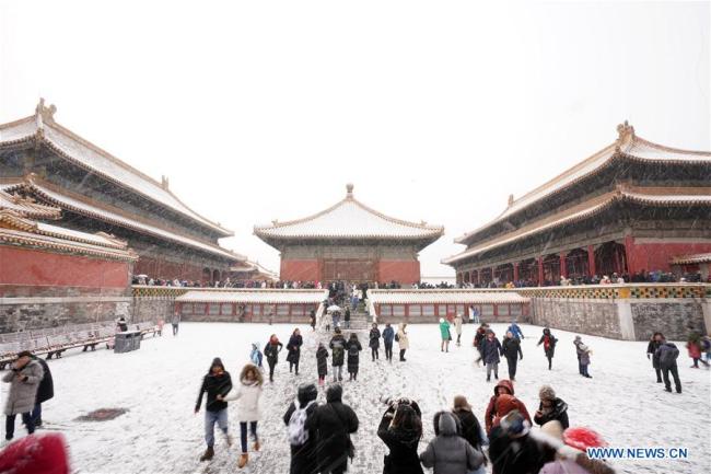 Des touristes admirent la Cité interdite enneigée à Beijing, capitale de la Chine, le 14 février 2019. Jeudi, une chute de neige a frappé Beijing. (Xinhua/Li Xin)