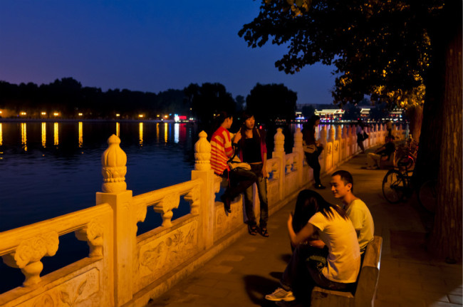 Les gens profitent de la fraîcheur au bord du lac Houhai à Beijing à la tombée de la nuit (Photo/ Christoph Mohr (Allemagne))