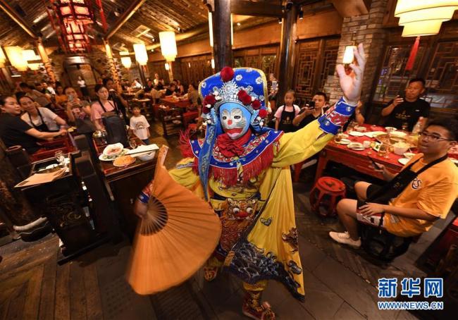 Photos prises le 4 août montrant un spectacle de l’opéra du Sichuan dans un restaurant de fondue situé dans les ruelles de Kuanzhai, à Chengdu. (Photo : Liu Kun/Xinhua)