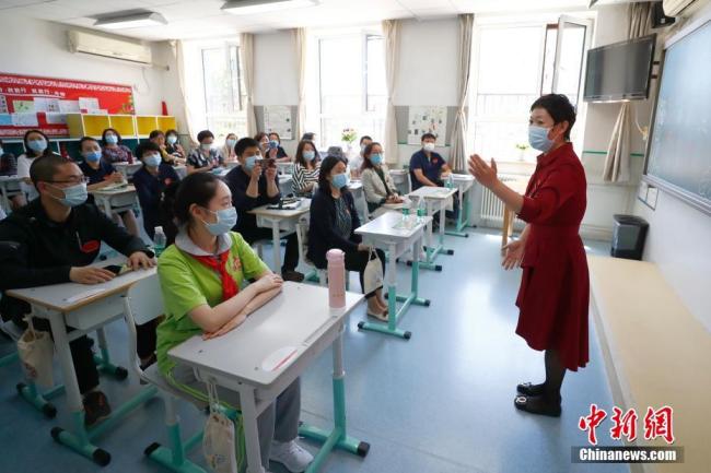 Photo prise le 26 mai, montrant une institutrice expliquant aux élèves les mesures anti-épidémiques à l'Ecole primaire Guangming de Beijing. (Photos : Fu Tian/Chinanews)