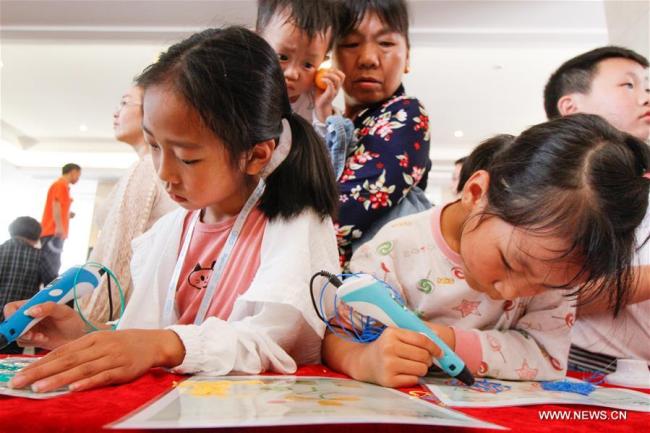 Des enfants utilisent des stylos d'impression 3D lors d'un festival de robotique pour la jeunesse, dans le district de Longhui de la province chinoise du Hunan (centre), le 5 mai 2018. (Photo : Zeng Yong)