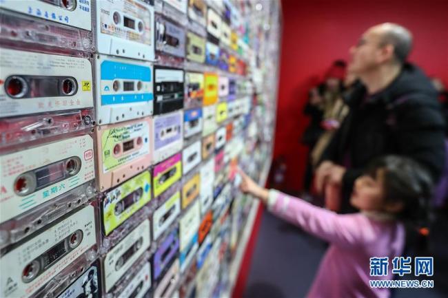 Des visiteurs regardent un mur de cassettes lors de l'exposition. Photo prise le 8 décembre.