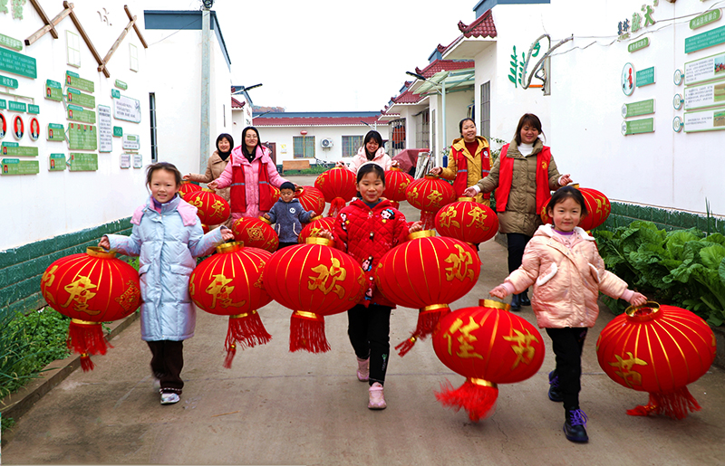 眉山仁壽：大紅燈籠高高挂 歡歡喜喜迎新年_fororder_當地黨員和志願者正在給群眾送燈籠