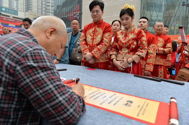 內江：太甜了 68對“新人”舉行集體婚禮_fororder_書法家為“新人”們書寫集體婚禮“婚書” (1).JPG