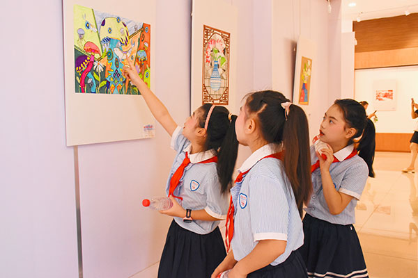 （張）德陽中江：“童心向黨 童畫六一”少兒美術作品展開幕_fororder_學生在畫作前交流