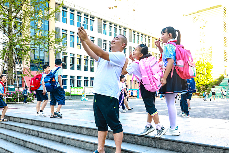 組圖｜瀘州合江：啟航喜迎新學期_fororder_8、9月1日，四川省瀘州市合江縣人民小學校，一名家長陪同孩子快樂地打卡合影-。