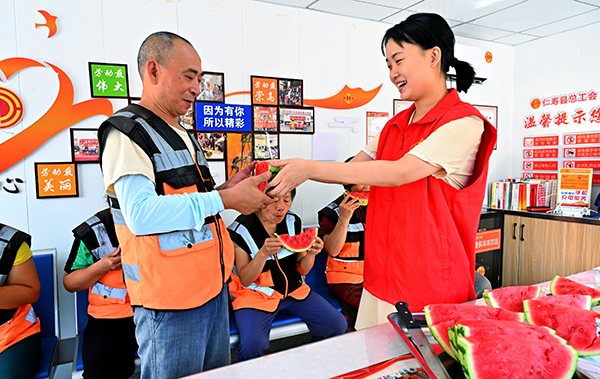 圖片默認標題_fororder_工會志願者正在給戶外勞動者送西瓜-攝影-潘建勇