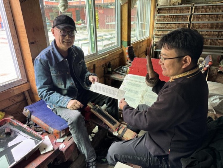 西博會啟幕 甘孜文旅憑非遺與自駕路線實力“圈粉”_fororder_沈寧強體驗雕版印刷  供圖 甘孜州委宣傳部