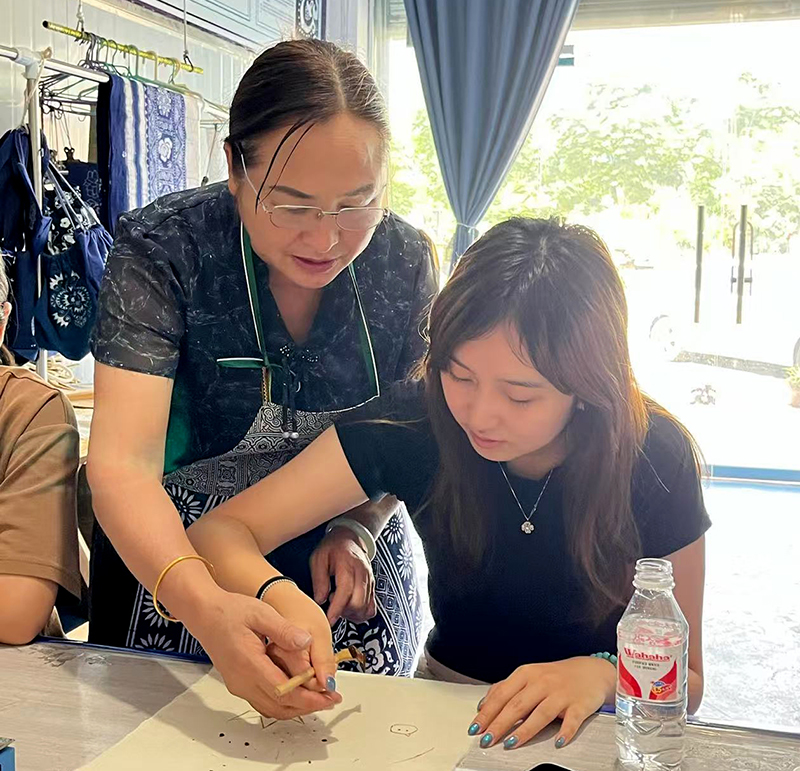 宜賓珙縣：大學生執蠟刀繪苗鄉匠心_fororder_熊宗會糾正學生正確使用蠟刀-攝影-文月嬌