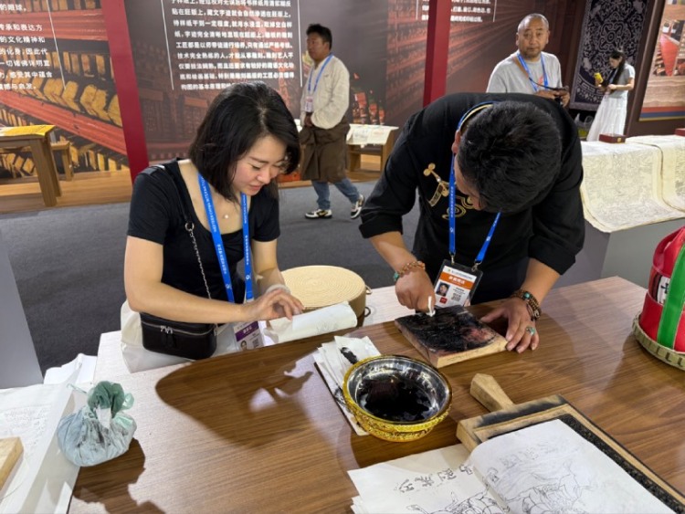 西博會啟幕 甘孜文旅憑非遺與自駕路線實力“圈粉”_fororder_西博會非遺展示互動體驗區正在體驗的觀眾 供圖 甘孜州委宣傳部