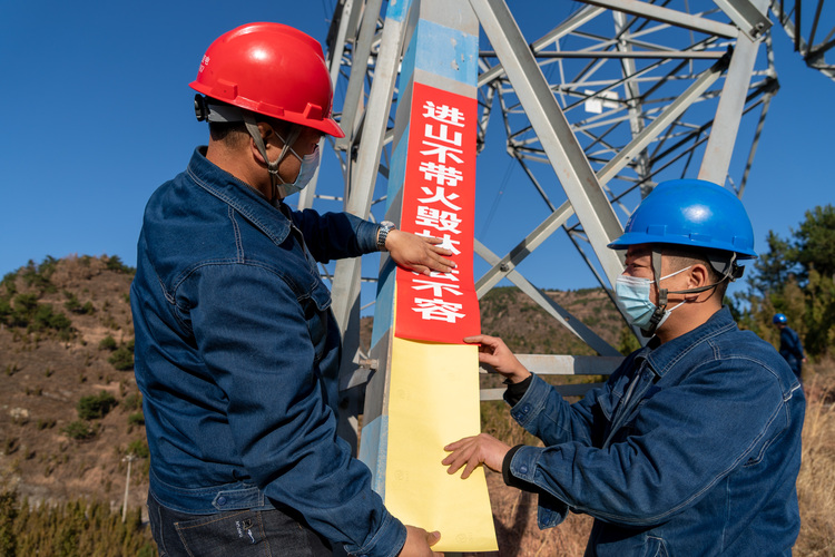 國網陜西電力：嚴防山火隱患 確保電網安全_fororder_國網陜西電力員工張貼防山火宣傳標語