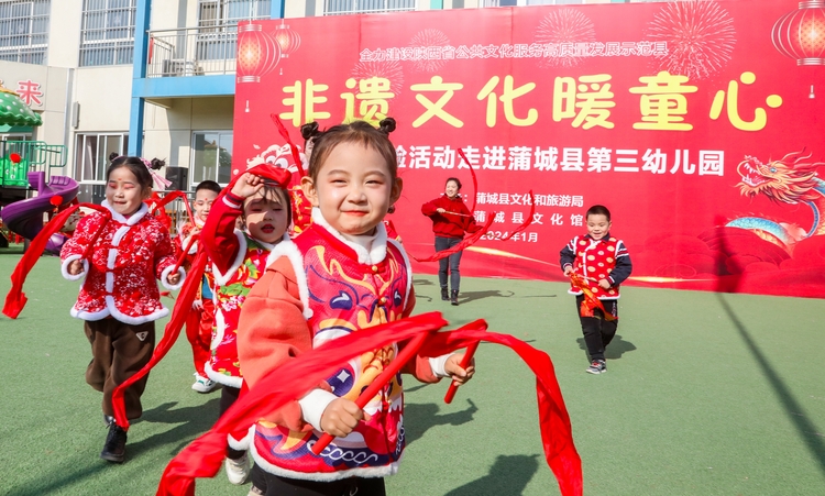 年味非遺進校園_fororder_2024年1月11日，陜西省渭南市蒲城縣開展“社火·廟會”非遺進校園活動中，孩子們有模有樣的表演著傳統秧歌