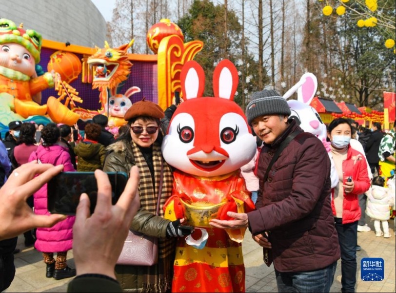 1月25日，在四川成都2023金沙太陽節活動現場，遊客和“招財兔”合影。新華社記者 王曦 攝
