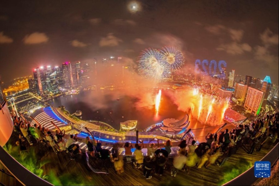 2023年1月1日，人們在新加坡濱海灣觀賞新年煙花與無人機燈光秀表演。新華社發（鄧智煒攝）