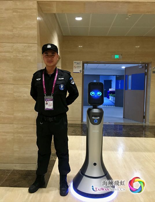 圖片默認標題_fororder_首屆中國國際進口博覽會上的場館保安與智慧機器人嚮導豹小秘 攝影：王竹