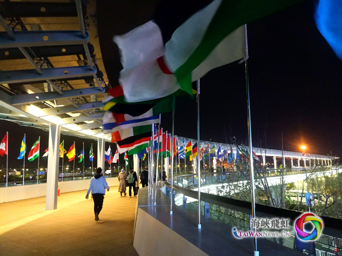 圖片默認標題_fororder_首屆中國國際進口博覽會 挂著參展國國旗的長廊 攝影：王竹