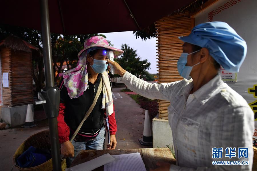 2月27日,白沙黎族自治縣五里路茶葉專業合作社的工人在進入茶園前測量體溫。 新華社記者 郭程 攝