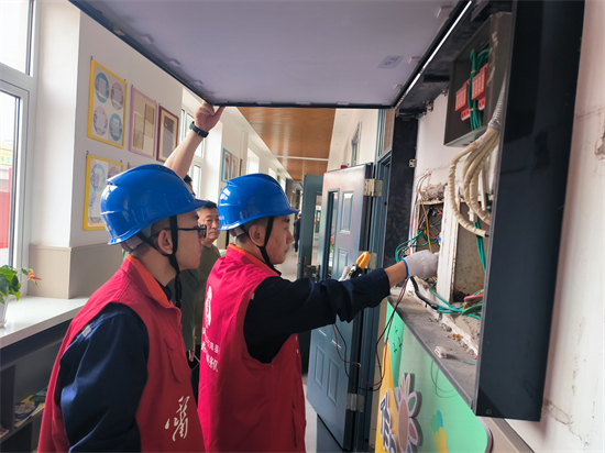 國網遼陽供電公司激活校園安全引擎_fororder_遼陽縣公司員工到首山鎮中心小學開展客戶側低壓配電箱及開關測溫,排查安全用電隱患。(康曉紅)