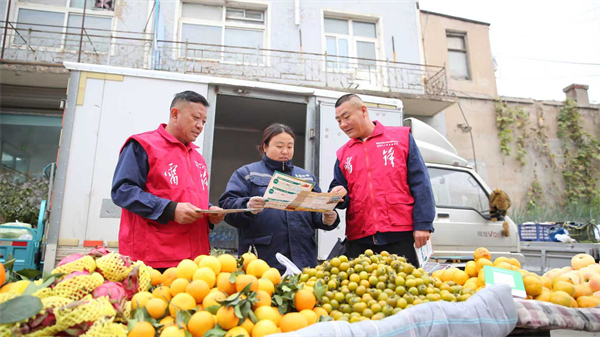 國網朝陽供電公司多維服務零距離 安全用電進鄉村_fororder_10月17日,國網朝陽供電公司淩北供電所工作人員在他拉皋民俗大集向商戶宣傳安全用電知識2(傅一凡攝)