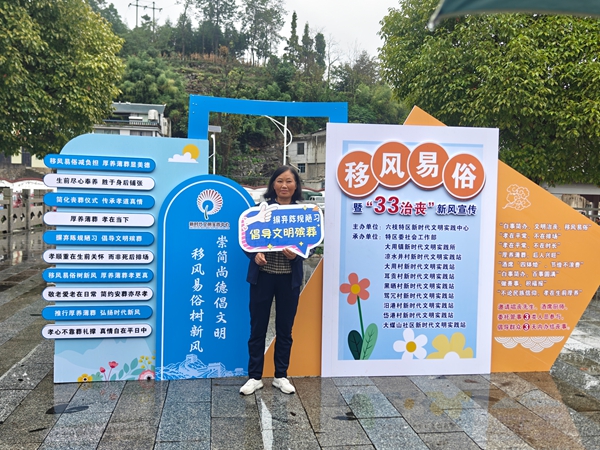 貴州六枝特區創新文明實踐活動宣傳移風易俗_fororder_群眾在宣傳欄前打卡