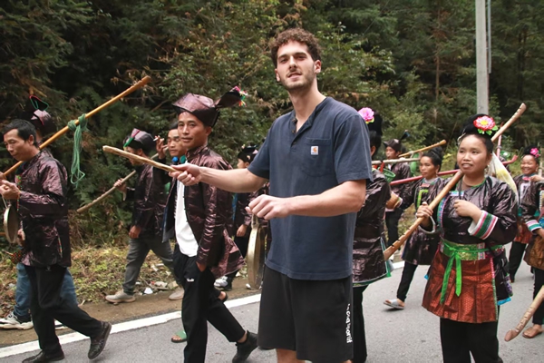 貴州黎平黃崗“香禾糯”節啟幕:千年侗寨品糯香 世界鄉村展新顏_fororder_外籍遊客進入巡遊隊伍親身體驗香禾糯節(陳玉攝)