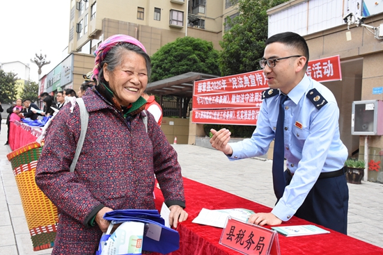 貴州畢節稅務開展“民法典宣傳月”系列活動_fororder_國家稅務總局赫章縣稅務局聯合司法、民政等部門開展第五個“民法典宣傳月”活動。圖為稅務幹部與司法、民政等部門工作人員通過設臺宣講、發放手冊等方式，向社區群眾普及稅法知識，解答發票開具、靈活就業參保等疑問、鄧萍
