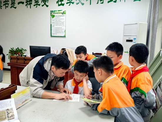 貴州荔波:在春日裏共赴書香之約_fororder_在荔波縣民族圖書館,老師和學生們一起探討交流。