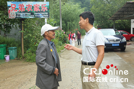 向內行走開闢精準扶貧新路徑  西安一基層老黨員讓幫困力量雙向流動_fororder_黨宏偉與李廣年老人交流。