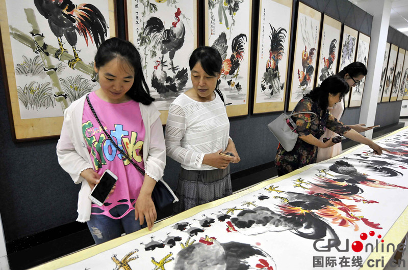 山東郯城：七旬老人舉辦“百雞畫展”慶七一_fororder_6月28日，觀眾在觀賞七旬老人張慶照舉辦的“雞年吉祥慶七一百雞畫展”上的國畫作品。DSC3666_副本