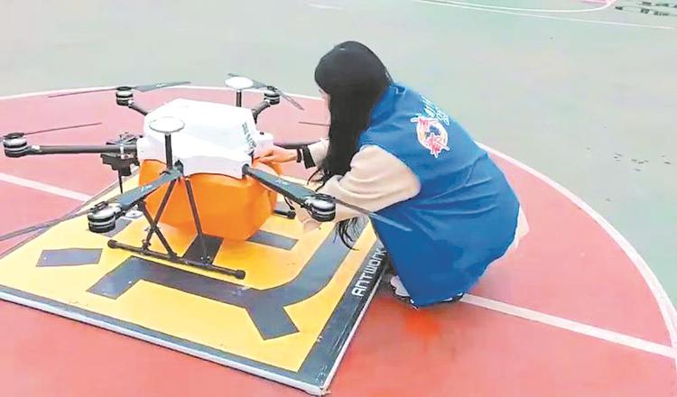 圖片默認標題_fororder_工作人員將文件資料裝上無人機。