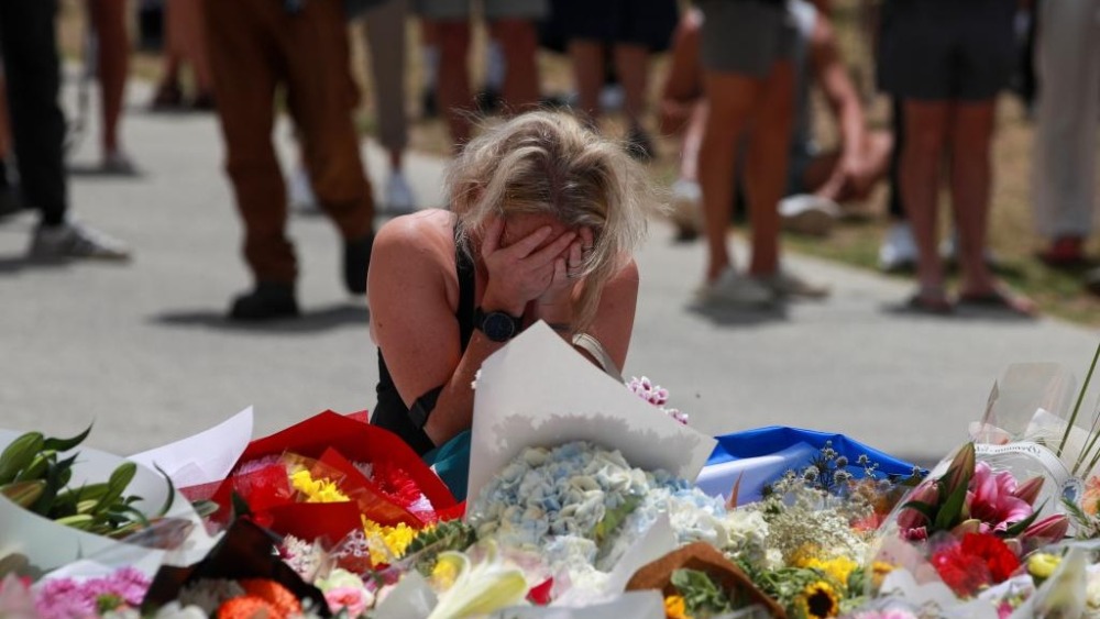 聽鑒世界 | 澳洲控槍協會官員：“娛樂射擊執照應該被廢除”_fororder_12月15日，在澳大利亞悉尼，一名女子在邦迪灘槍擊事件現場附近悼念遇難者